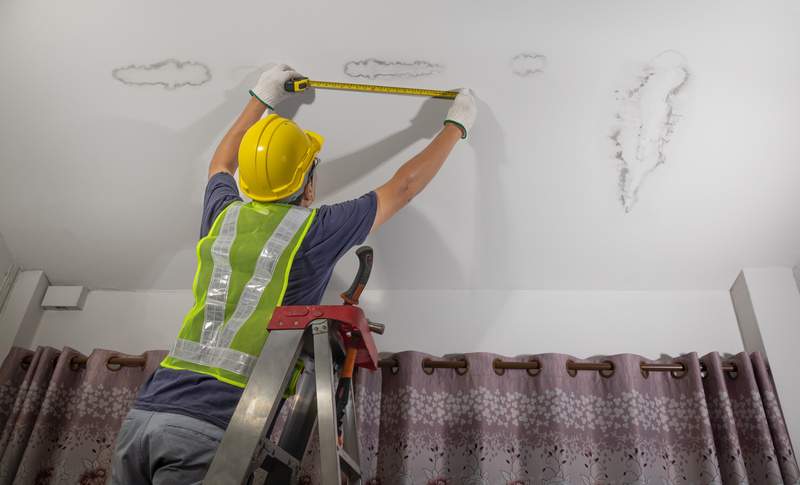 Worker fix leaking pipe in ceiling ,close-up of a stain on the ceiling.